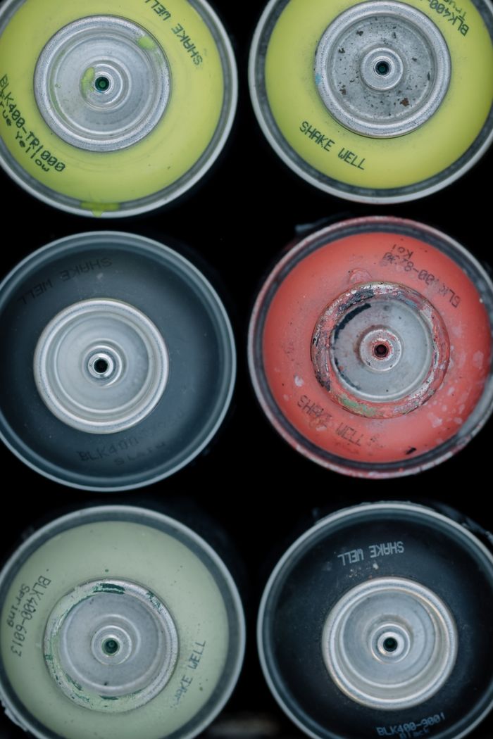 Portfolio Close-up of various colored spray paint cans viewed from above.
